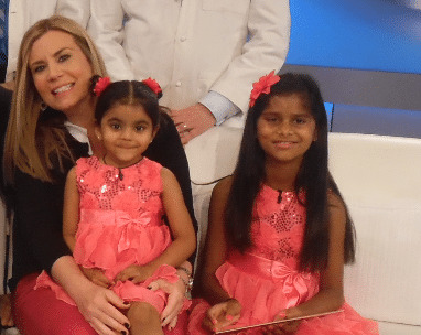 Two girls and a woman in pink dresses.