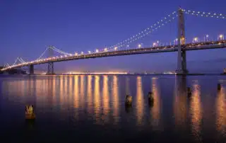 A large bridge that is lit up at night.