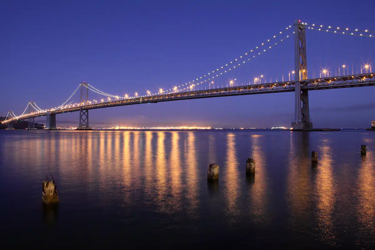 A large bridge that is lit up at night.