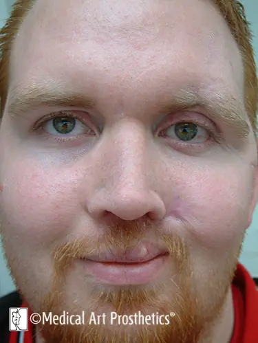 A man with red hair and green eyes.