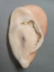 A person 's ear with an earring in it.