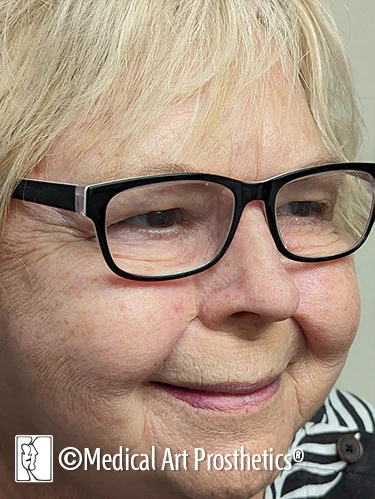 A close up of an older woman wearing glasses